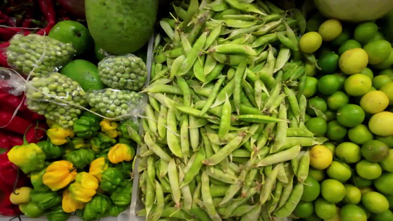Top down Grains or seed of Pisum sativum with Lycopersicon esculentum. Green chilli or pea grains with Green chilli or garden pea seeds or grains with Green and red chillies.