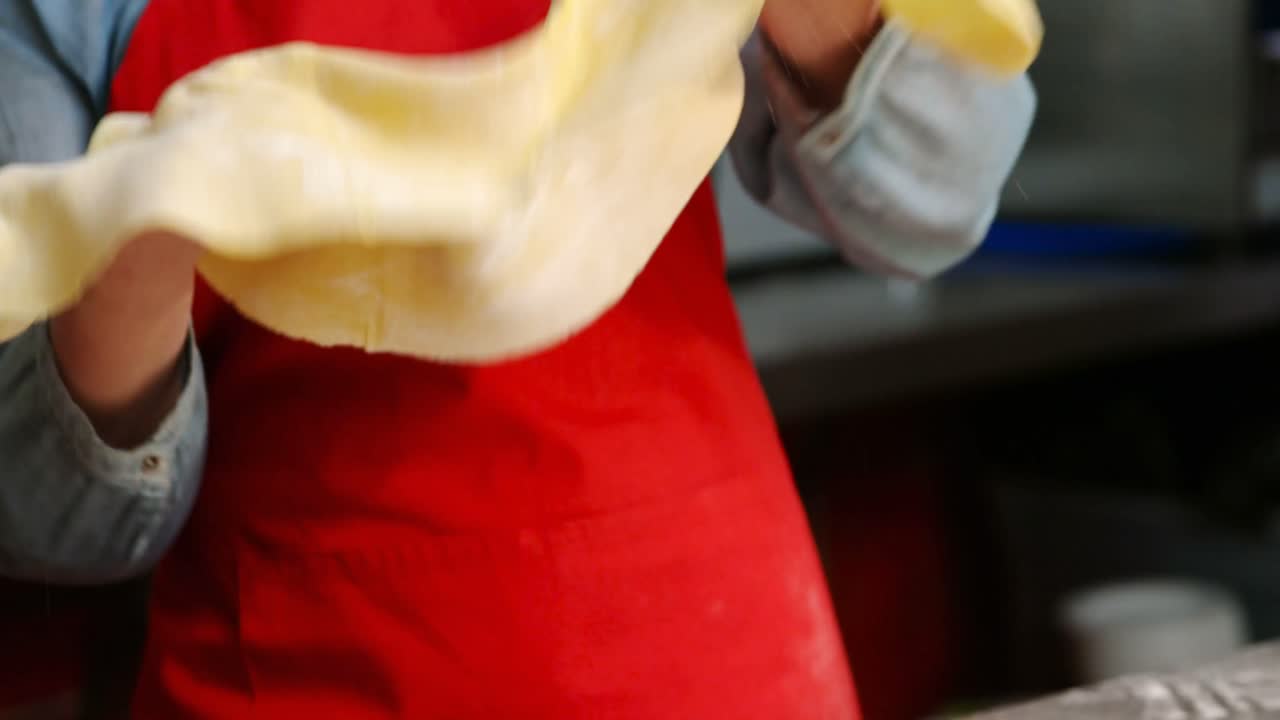 panadera que sostiene la masa en la panadería 4k