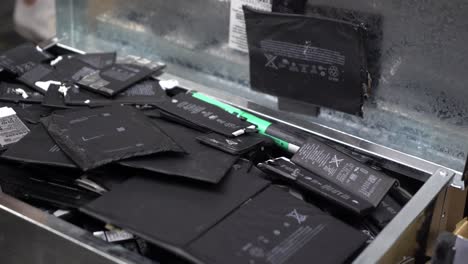 Opening A Box Of Used Phone Batteries With A Pan