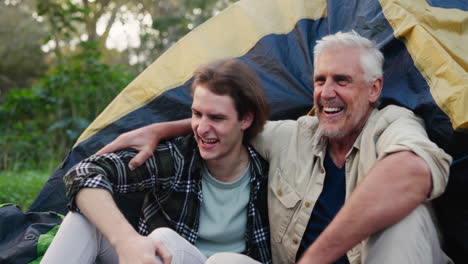 father and son camping in tent