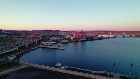 twilight aerial shot over new haven, ct, highlighting the city's roads and harbor at sunset