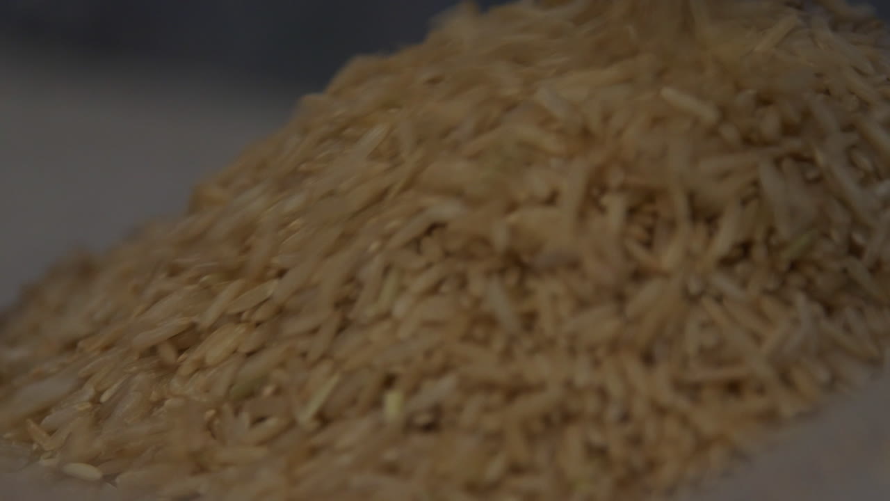Deep Focus Close up of Brown rice being poured into a container