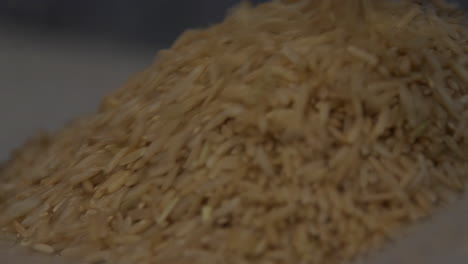 Deep-Focus-Close-up-of-Brown-rice-being-poured-into-a-container