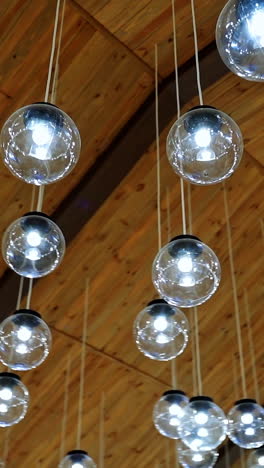 crystal balls hanging from brown ceiling. beautiful ceiling with round glass light bulbs. motion camera around. vertical video