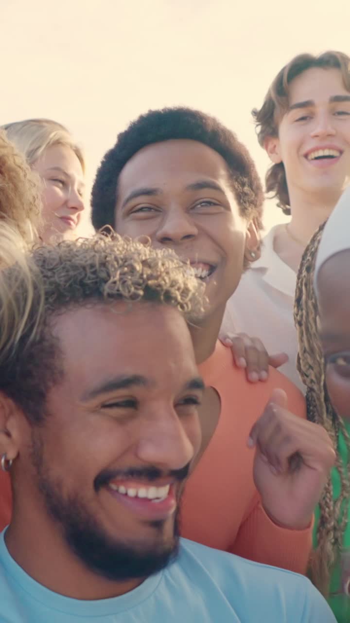 Latin young man taking a happy selfie with multi-ethnic friends
