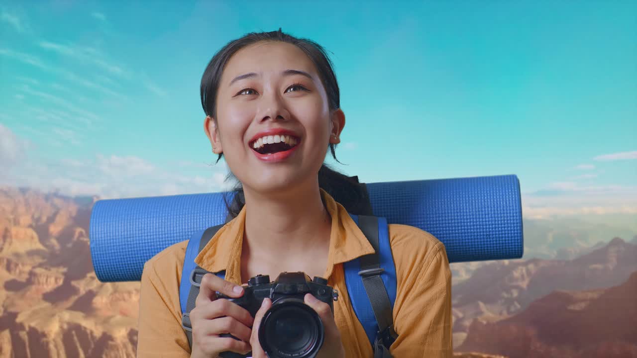Close Up Of Asian Female Hiker With Mountaineering Backpack Smiling And Holding A Camera In Her Hands Then Looking Around While Traveling At The Top Of Mountain