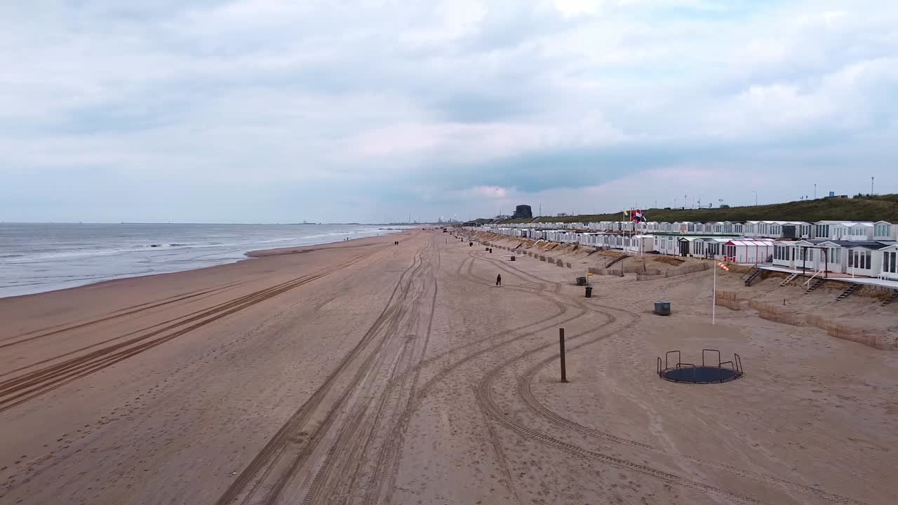 toma de drone de la playa del mar del norte con cabañas a la derecha.