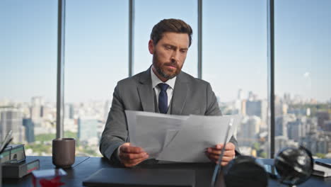 ceo exitoso leyendo papeles en el escritorio de la oficina. gerente pensativo que tiene contrato