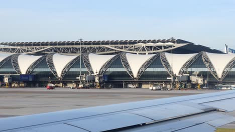 airplane moves past terminal at bangkok airport