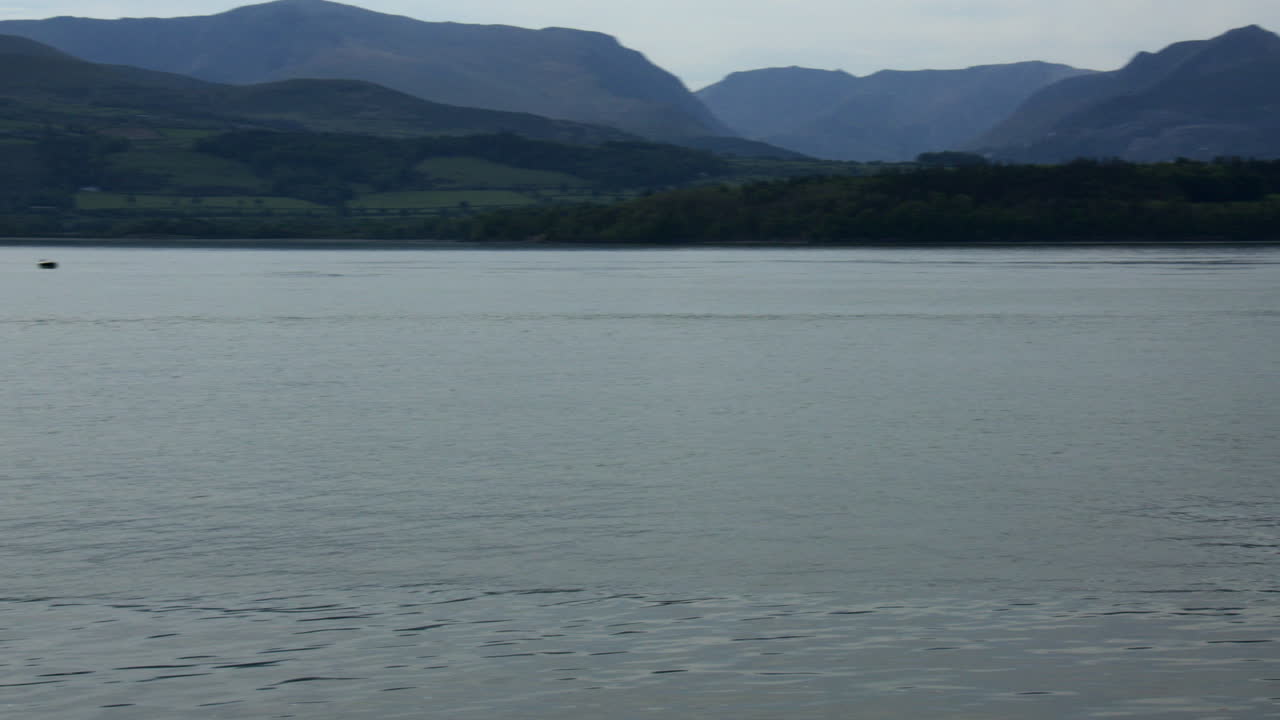 Panning Wide shot Looking up and down the Menai Strait at Gallows point,