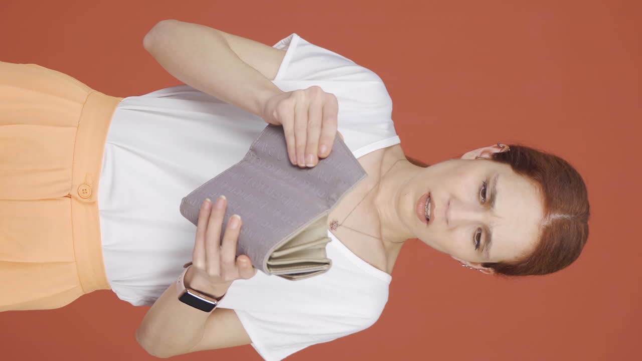 вертикальное видео бедняжки, смотрящей на свой пустой кошелек.