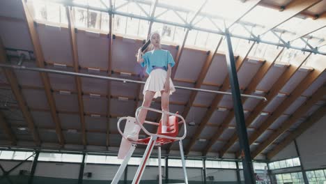 fashionable woman posing on tennis court chair