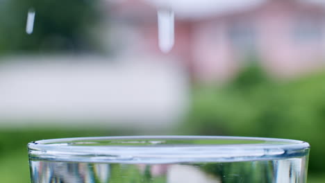 droplets of water are formed as water lands into a glass filled with clean, clear water