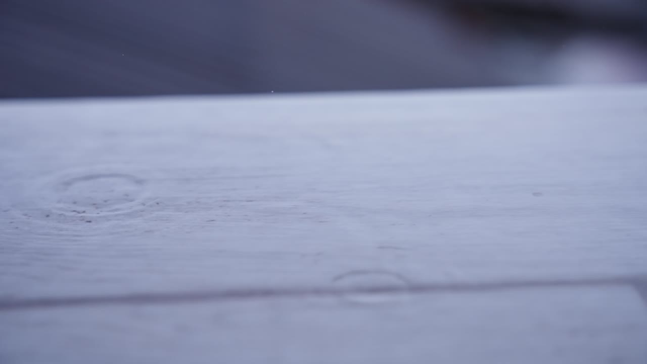 gocce di pioggia sul pavimento di legno del balcone