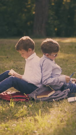 cute children in shirts sit back to back preparing for school tests with textbooks in pictorial garden