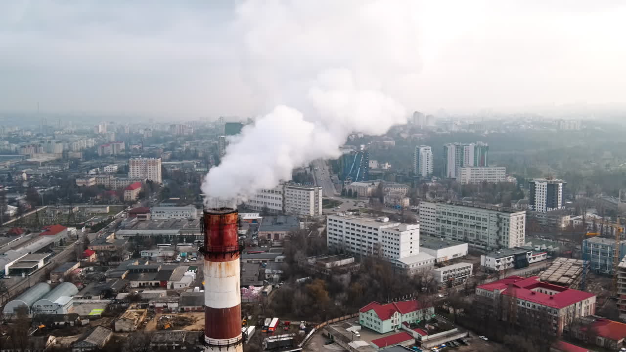 Cityscape of Chisinau from a drone at cloudy weather, thermal station with smoke getting out, buildings and bare trees in Moldova