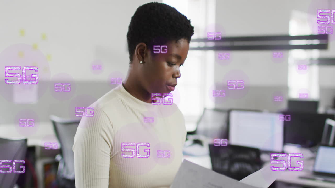 Animation of 5g text over biracial businesswoman checking documents