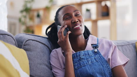 Phone-call,-funny-and-black-woman-on-sofa-in-home