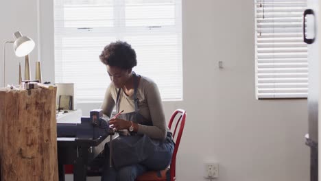 busy african american female worker doing design of jewellery in workshop in slow motion
