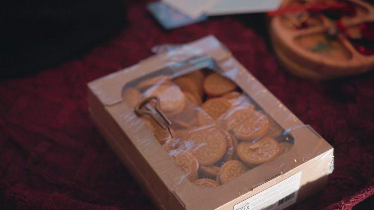 Fortune cookie gift box on velvet table, small brass key and dried orange slice beside artisan cookies, warm candlelit ambience creates cozy mystic ritual and subtle foresight mood for celebration