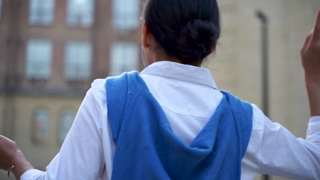 cheerful woman listening to music with earphones and walking down the street 1