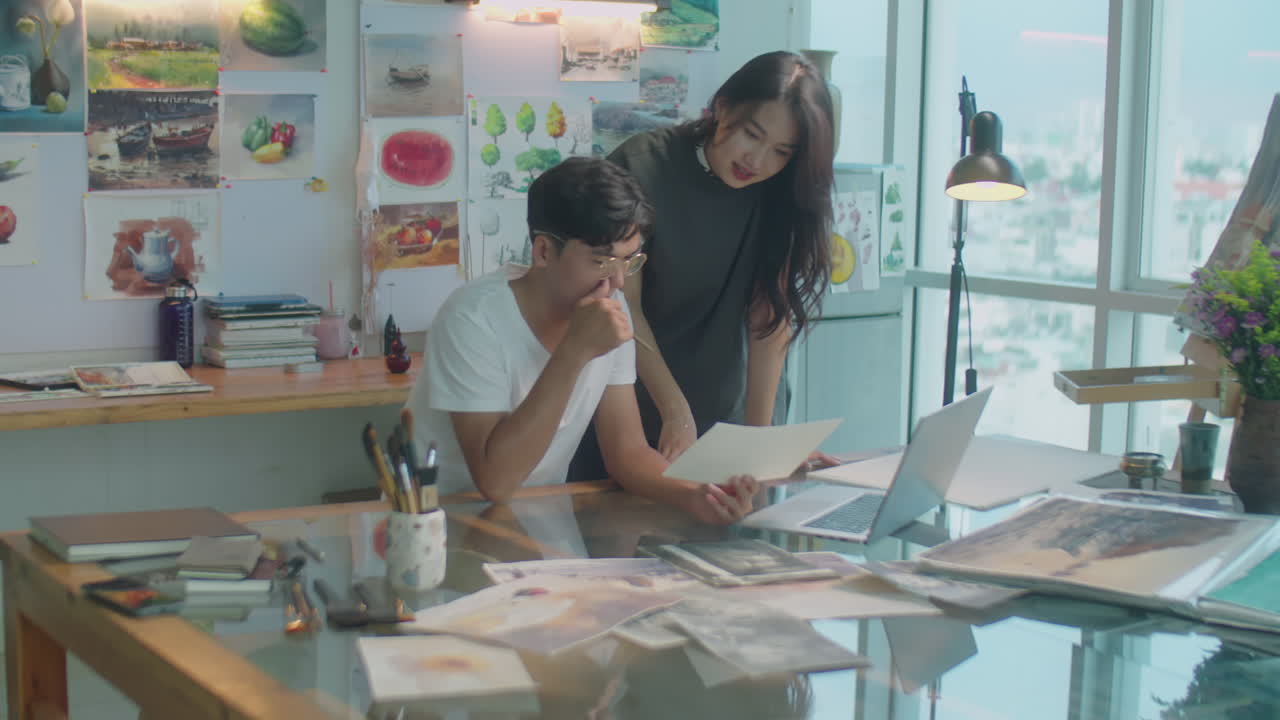 Asian Designers Discussing Painting in Creative Studio