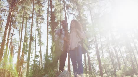 smiling diverse couple looking away and hiking in countryside