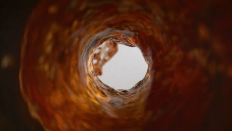 coffee vortex flowing out of the inside of coffee machine and pouring into milk in macro and slow motion