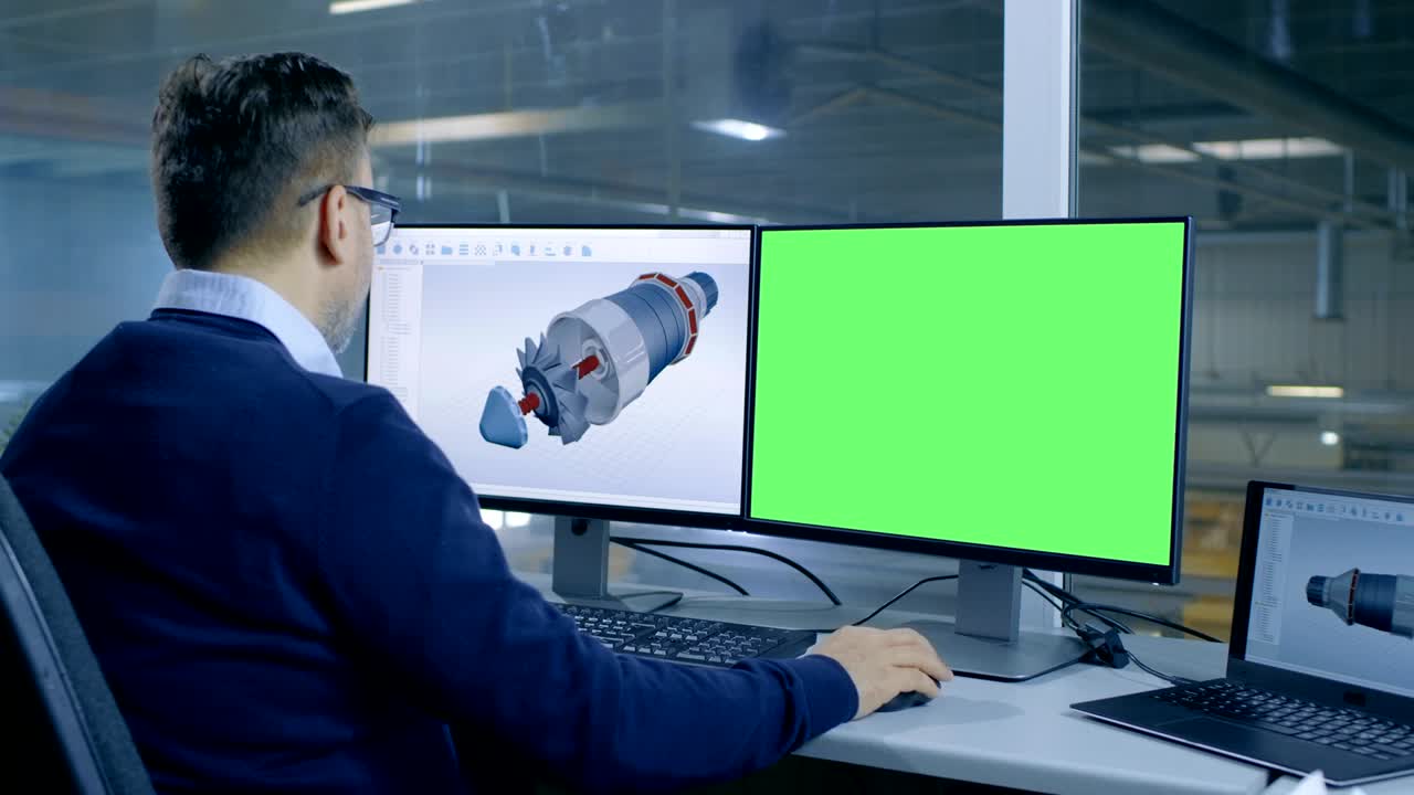 el ingeniero jefe diseña una turbina o un motor 3d para una gran empresa industrial, su segunda pantalla muestra una maqueta de una computadora de pantalla verde. fuera de la ventana de la oficina se ve una gran fábrica.