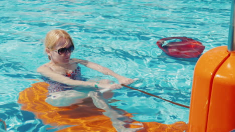 junge frau, die draußen im pool im resort trainiert