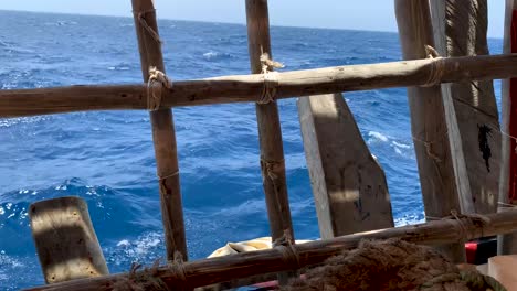 el mar arábigo parece muy azul desde la parte trasera del barco de madera.