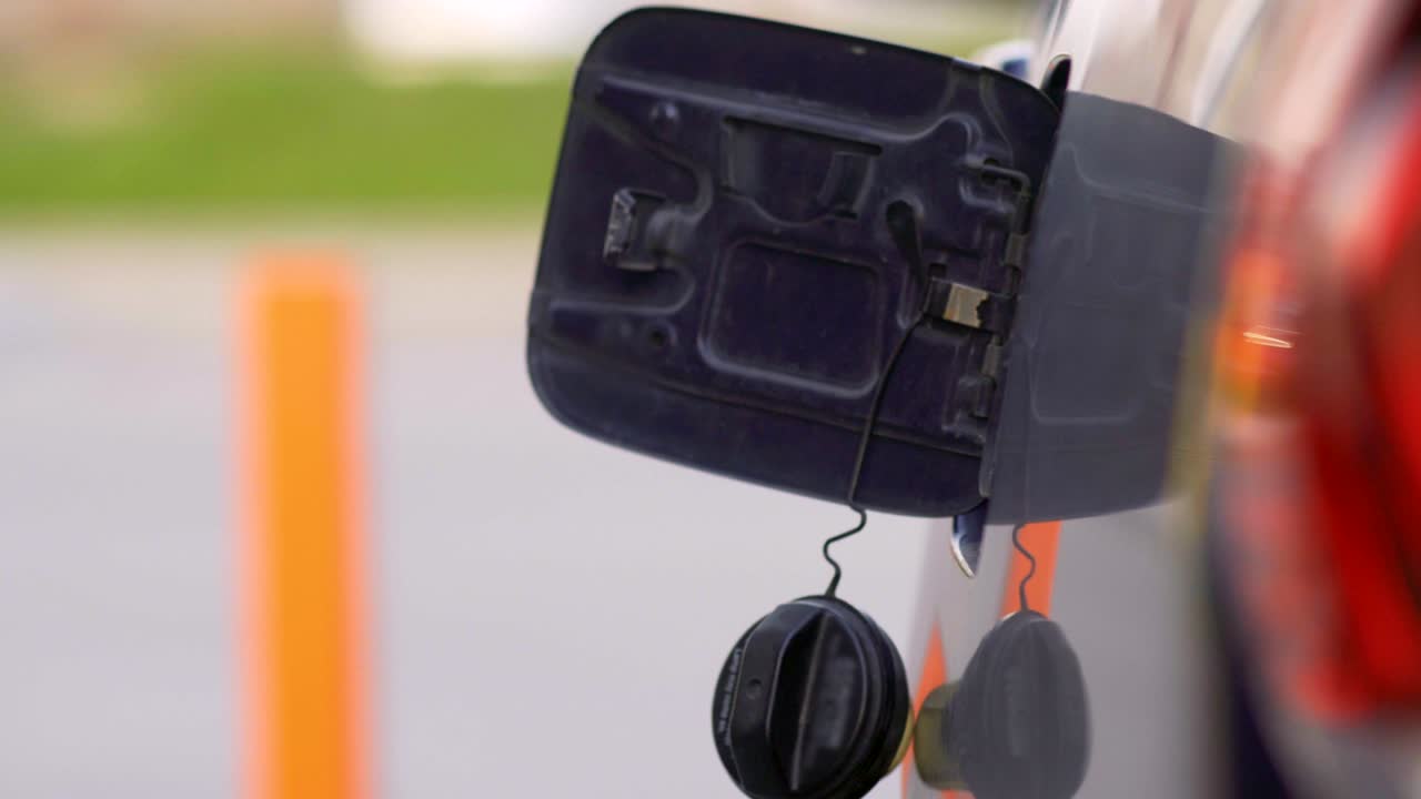 한 여성이 주유소에서 가솔린 차를 운전하고 있습니다. 근접 촬영.