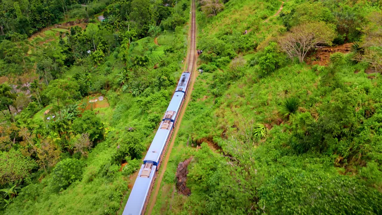 Captivating aerial drone footage of a train crossing the iconic railway bridge in Ella, Sri Lanka.