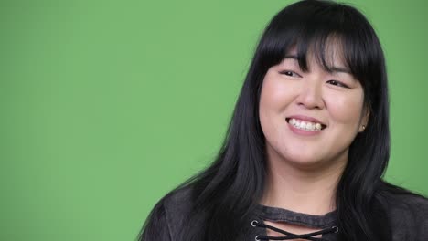 beautiful overweight asian woman smiling and thinking