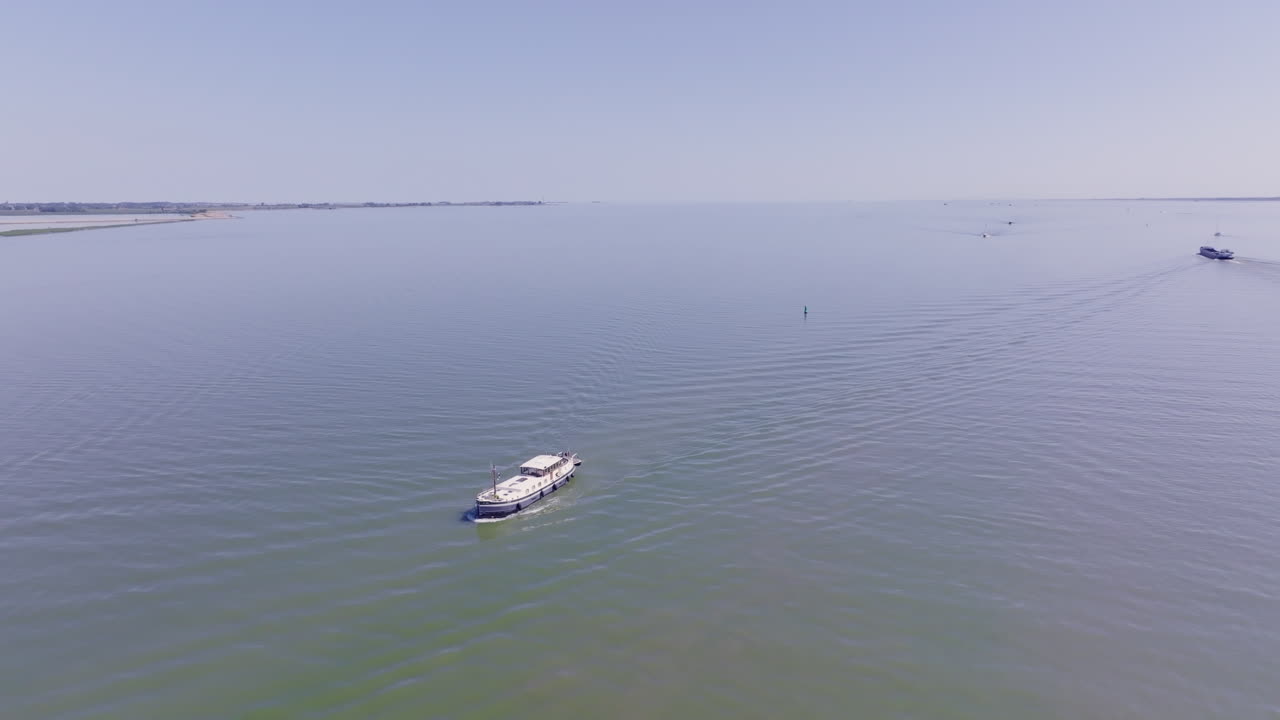 Serene drone footage of a traditional Luxemotor vessel sailing smoothly in the Netherlands