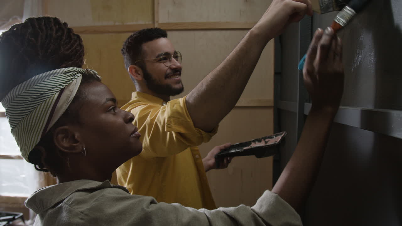pareja pintando una pared juntos