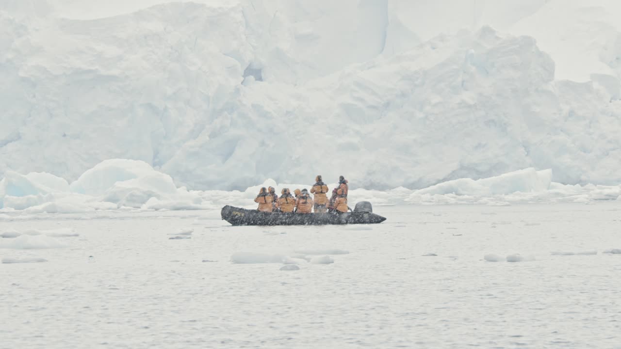 Stable shot of people looking at a big glacier during snow storm and other bad weather