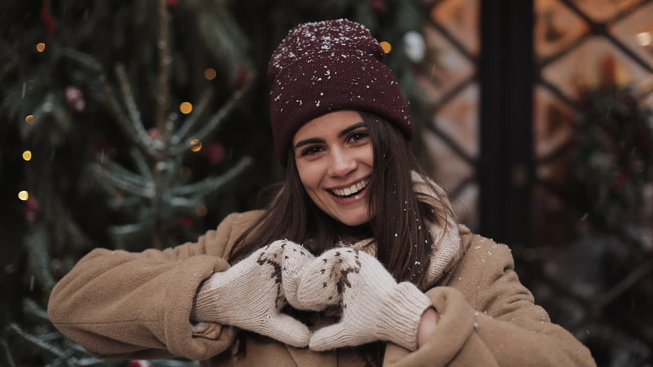 Happy Woman Making Heart Shape in Winter