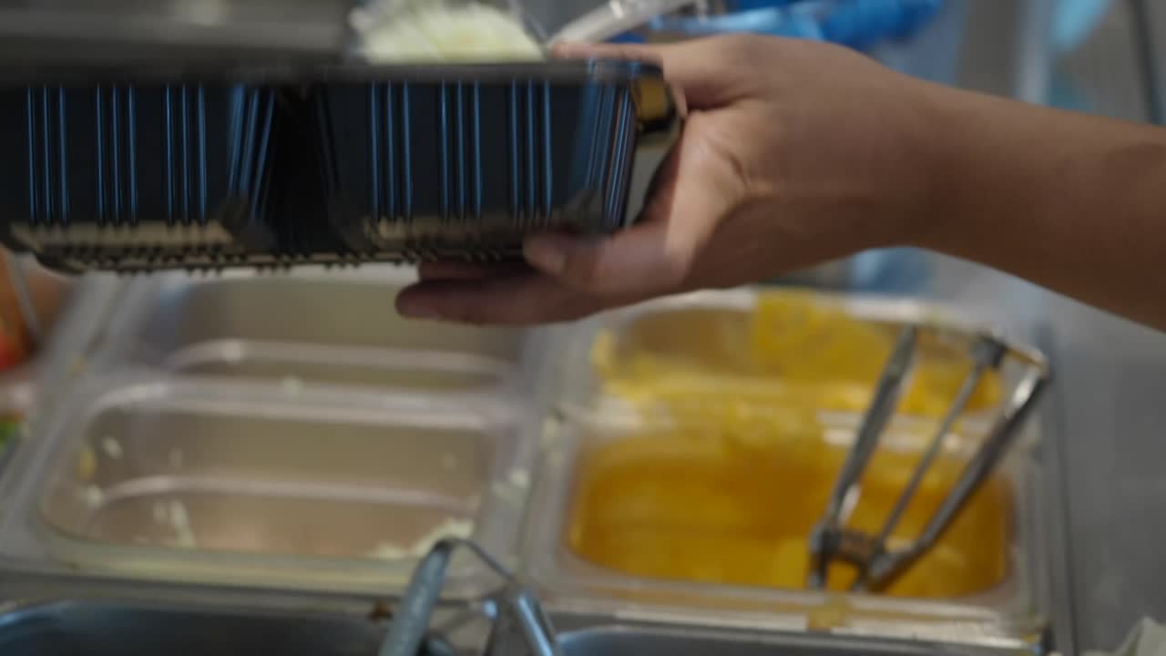 Food being prepared in takeout containers