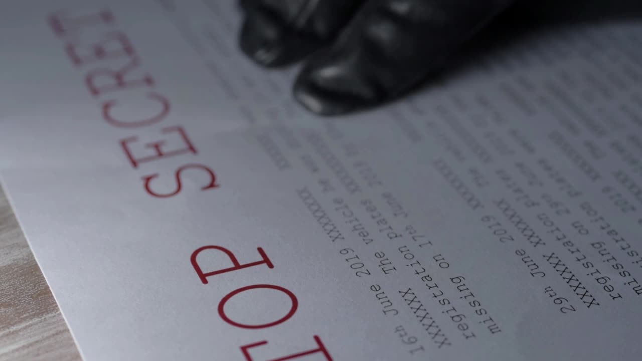 Black glove reading top secret document containing classified information