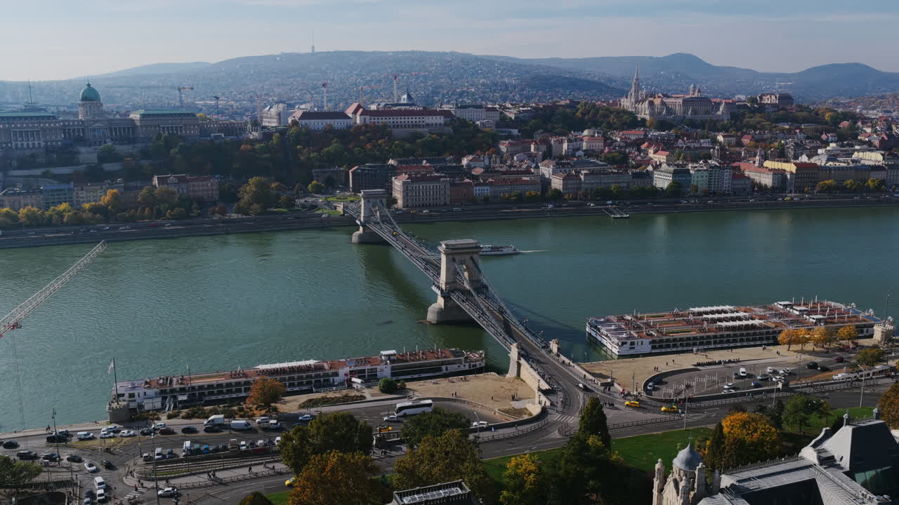 The Széchenyi Chain Bridge spans the Danube River, connecting Buda and Pest with Buda Castle and Matthias Church seen in the background