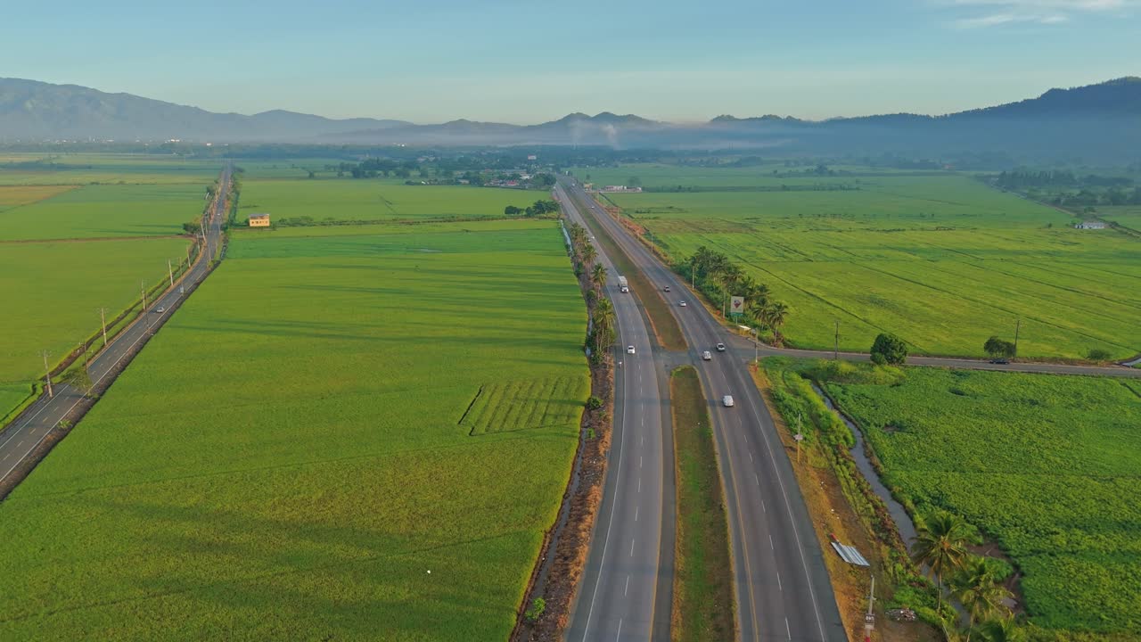 Traffic Over Duarte Highway Crossing Countryside Rice Fields At Bonao In Dominican Republic. Aerial Drone Shot