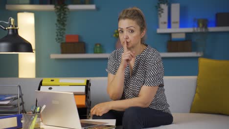 Home-office-worker-woman-says-shhh-to-camera.