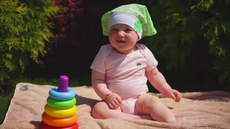 baby girl playing outdoors with stacking rings