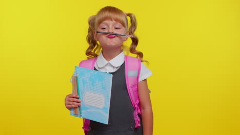 ein junges mädchen in schuluniform hält ein notizbuch und einen bleistift, während es ein lustiges gesicht macht