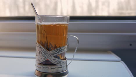 tea in the cup holder is on the table in the train compartment 4k video