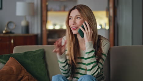 Smiling lady calling friends by smartphone at home close up. Happy woman talking