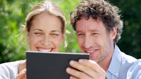 una pareja feliz mirando una tableta.