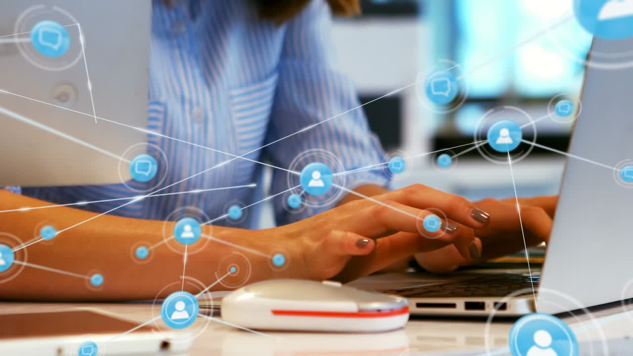 animación de una red de iconos digitales contra la sección media de una mujer que usa una computadora portátil en la oficina