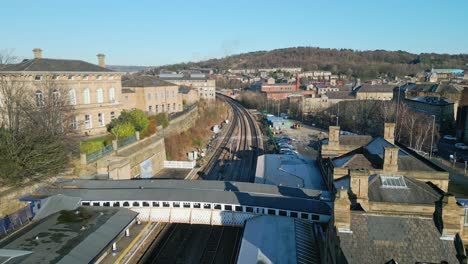 Filmische-Drohnenaufnahmen-Aus-Der-Luft-Eines-Bahnhofs-Mit-Bahnsteig-Und-Parkplatz-In-Großbritannien